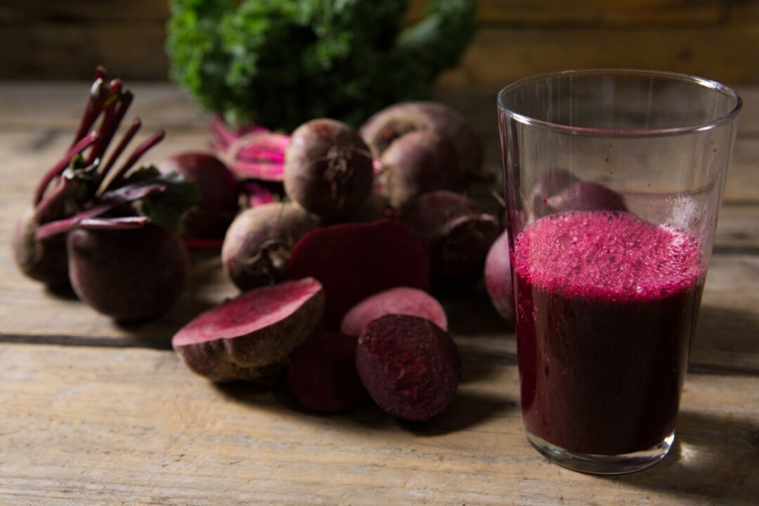 Glas mit Rote-Bete-Saft, daneben aufgeschnittenene Knollen