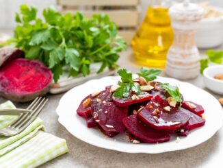 Rote Beete auf einem weißen Teller, daneben Olivenöl und Gemüse