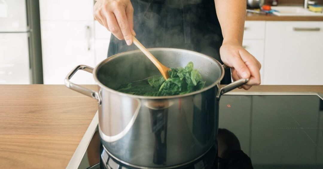 Spinat beim Kochen im Topf – durch Erhitzen und Blanchieren kann der Oxalsäuregehalt reduziert werden.