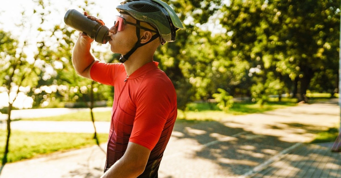 Radfahrer trinkt unterwegs aus der Trinkflasche